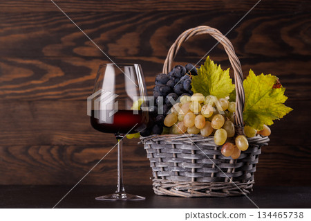 Red wine glass and basket of fresh grapes Red wine glass and basket of fresh grapes 134465738