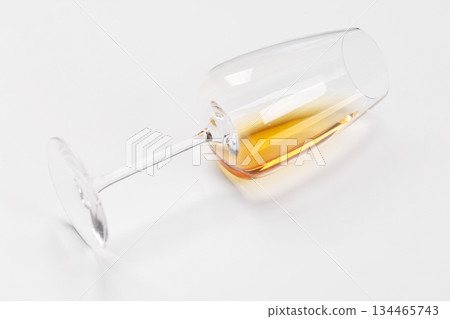 Wine glass with white wine lying on white background Wine glass with white wine lying on white background 134465743