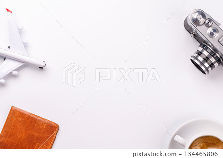 Travel-themed flat lay with toy airplane, camera, and coffee 134465806
