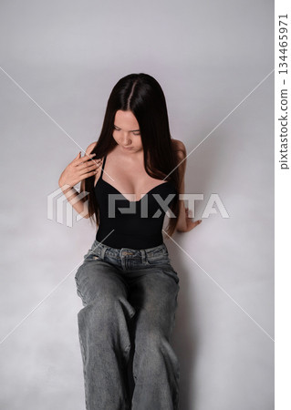 Woman fashion studio portrait of young model in casual black top and jeans Woman fashion studio portrait of young model in casual black top and jeans 134465971