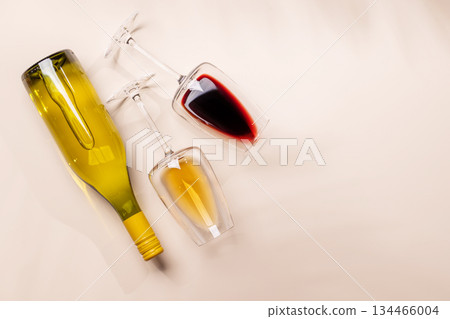 Wine glasses with red and white wine lying on beige background Wine glasses with red and white wine lying on beige background 134466004