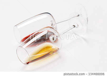 Wine glasses with red and white wine lying on white background Wine glasses with red and white wine lying on white background 134466006