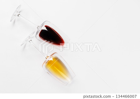 Wine glasses with red and white wine lying on white background Wine glasses with red and white wine lying on white background 134466007