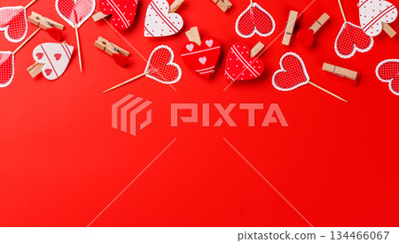 Various heart-shaped decorations arranged on a red background with ample copy space 134466067