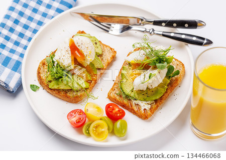 Delicious avocado toasts topped with perfectly cooked poached eggs 134466068
