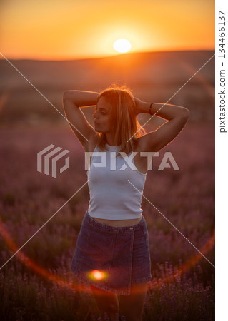 Woman lavender sunset standing peaceful field during warm summer golden hour light Woman lavender sunset standing peaceful field during warm summer golden hour light 134466137