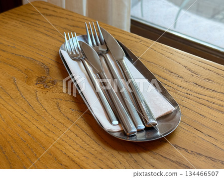 Stainless cutlery set on wooden table. Minimalism, order and elegant preparation for dining. Stainless cutlery set on wooden table. Minimalism, order and elegant preparation for dining. 134466507