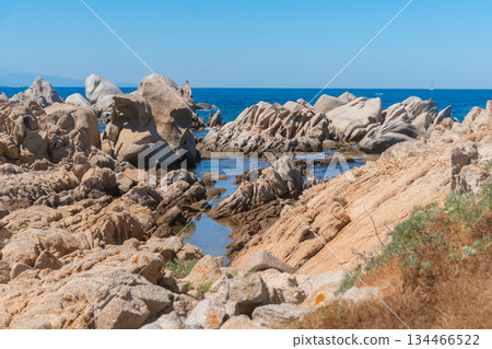 Rocky coastline with clear blue sea under bright sunlight. Natural seaside landscape, coastal geology and summer travel destination with a calm and relaxing atmosphere, Sardinian, La Maddalena, Italy Rocky coastline with clear blue sea under bright sunlight. Natural seaside landscape, coastal geology and summer travel destination with a calm and relaxing atmosphere, Sardinian, La Maddalena, Italy 134466522