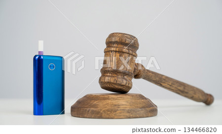 Judge's gavel and electronic cigarette. Smoking ban. Tobacco heating systems. Judge's gavel and electronic cigarette. Smoking ban. Tobacco heating systems. 134466820