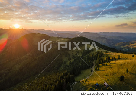 Amazing mountain landscape. Dark spruce woods illuminated with yellow setting sun. Bright colorful sunset in wild national park highlands Amazing mountain landscape. Dark spruce woods illuminated with yellow setting sun. Bright colorful sunset in wild national park highlands 134467165