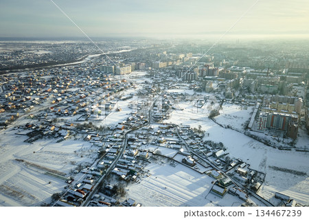 Aerial view of private homes with snow covered roofs in rural suburbs town area in cold winter 134467239
