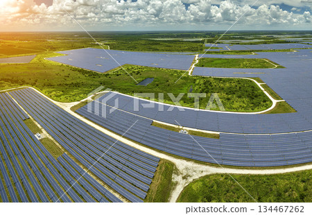 Aerial view of large sustainable electrical power plant with rows of solar photovoltaic panels for producing clean electric energy. Concept of renewable electricity with zero emission Aerial view of large sustainable electrical power plant with rows of solar photovoltaic panels for producing clean electric energy. Concept of renewable electricity with zero emission 134467262
