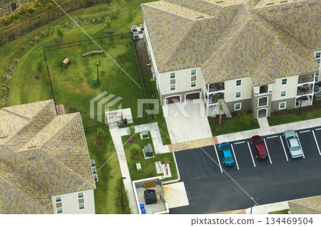 Aerial view of cars parked on parking places at american apartment building in Florida residential area. New family condos as example of housing development in US suburbs Aerial view of cars parked on parking places at american apartment building in Florida residential area. New family condos as example of housing development in US suburbs 134469504
