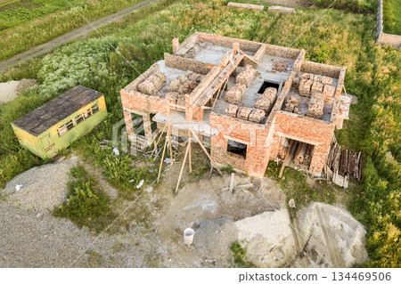 Aerial view of building site for future house, brick basement floor and stacks of brick for construction. Aerial view of building site for future house, brick basement floor and stacks of brick for construction. 134469506