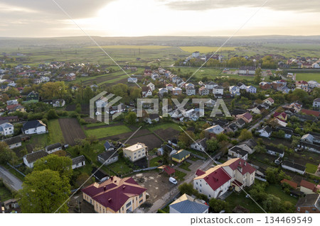 Aerial landscape of small town or village with rows of residential homes and green trees. Aerial landscape of small town or village with rows of residential homes and green trees. 134469549