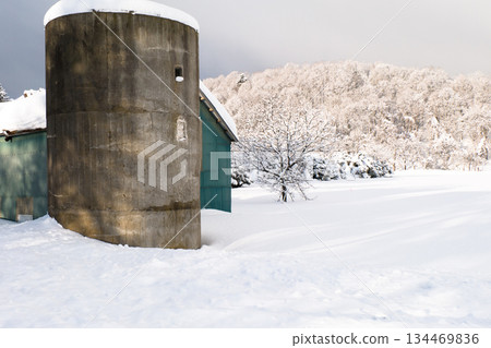 白雪皚皚的鄉村,清晨寧靜祥和。房屋和糧倉的屋頂上覆蓋著積雪。 白雪皚皚的鄉村,清晨寧靜祥和。房屋和糧倉的屋頂上覆蓋著積雪。 134469836