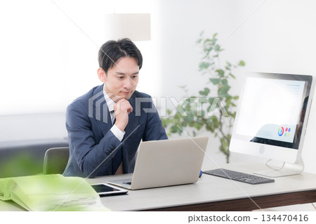 Looking at the graphs of business strategies and results, CEOs and managers' success images of increasing sales. Looking at the screen, thinking. 134470416