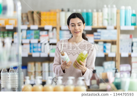 woman chooses a shampoo in a pharmacy 134470593