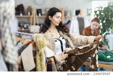 Armenian girl near showcase examine goods, buying warm dress. Armenian girl near showcase examine goods, buying warm dress. 134470597