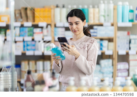 woman scans the barcode of a mouthwash in a pharmacy woman scans the barcode of a mouthwash in a pharmacy 134470598