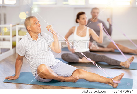 Elderly man exercising with pilates loop 134470684