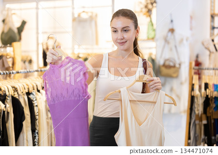 Woman choosing between two blouses 134471074