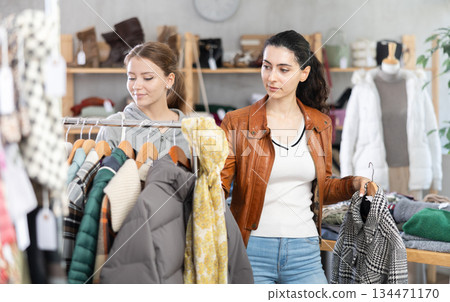 Armenian girl near showcase examine goods, buying something autumn outwear. Armenian girl near showcase examine goods, buying something autumn outwear. 134471170