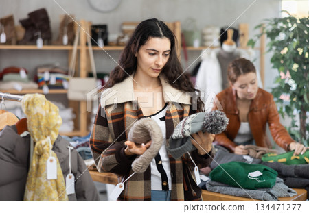 Armenian woman near showcase examine goods, hat. 134471277