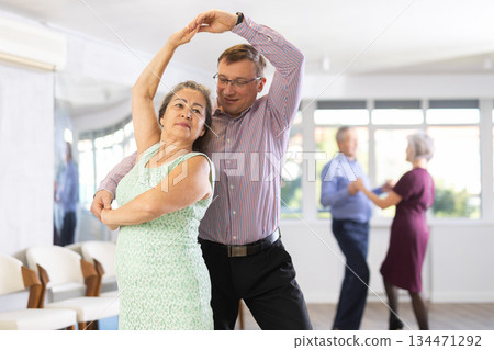 Adult man and elderly woman dance waltz 134471292
