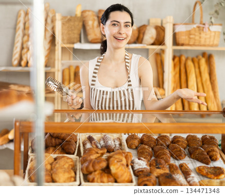 Young woman seller at showcase with pastries 134471348