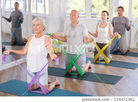 Elderly woman exercises with pilates band 134471362