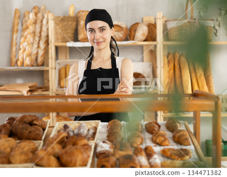 Young woman seller at showcase with pastries 134471382