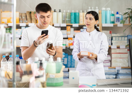 Man buyer scans syrup qr code with woman pharmacist Man buyer scans syrup qr code with woman pharmacist 134471392