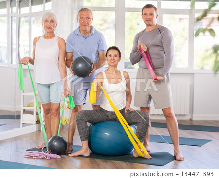 Group of men and women posing with pilates equipment 134471393