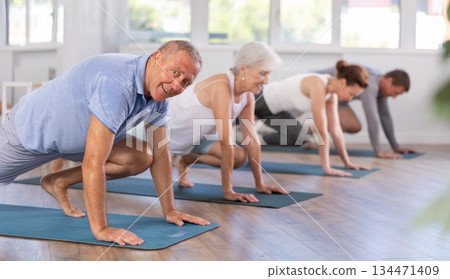 Elderly man doing pilates in group 134471409