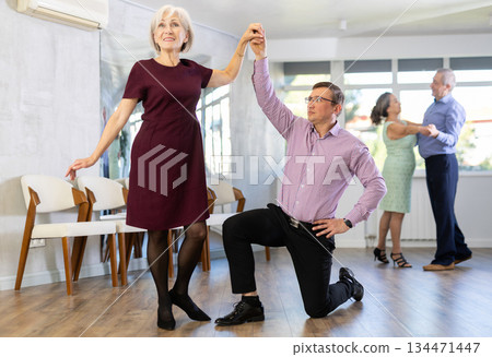 Adult man and elderly woman dance waltz 134471447