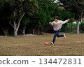 一位母親和她的孩子在公園裡踢足球。 134472831