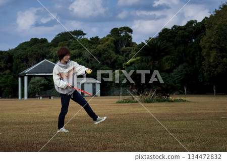 一位女士在公園打網球。 134472832
