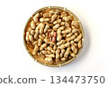 A large number of shelled peanuts in a bamboo basket on a white background, viewed from directly above 134473750