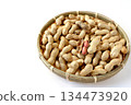 A lot of shelled peanuts in a bamboo basket on a white background 134473920