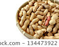A lot of shelled peanuts in a bamboo basket on a white background 134473922