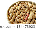 A lot of shelled peanuts in a bamboo basket on a white background 134473923