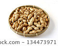 A lot of shelled peanuts in a bamboo basket on a white background 134473971