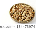 A lot of shelled peanuts in a bamboo basket on a white background 134473974