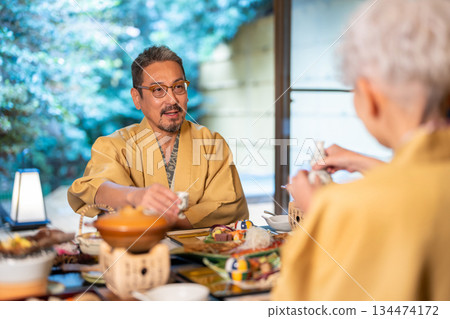 一對老年夫婦在旅館服務，提供飲料。 134474172
