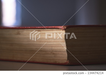 Book lies open on a table with light shining on it. Book lies open on a table with light shining on it. 134474214