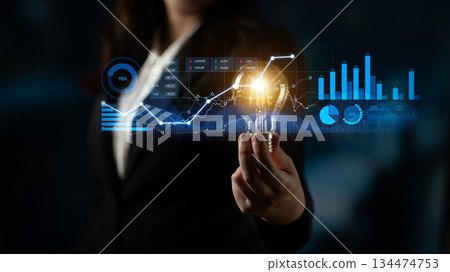 Business professional holding light bulb with charts and graphs in background representing innovation, analysis, and growth strategies in finance sector Scalp Business professional holding light bulb with charts and graphs in background representing innovation, analysis, and growth strategies in finance sector Scalp 134474753
