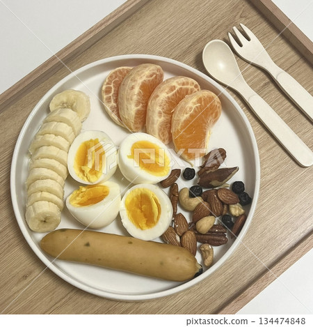 A delightful brunch spread featuring a mix of savory and sweet dishes, including fresh pastries, eggs, seasonal fruits, and a hot beverage. A perfect mid-morning indulgence. 134474848