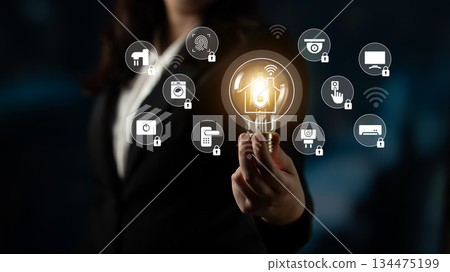 Businesswoman in Suit Holding Light Bulb with Smart Home Technology Icons Representing Innovation and Connectivity in Digital World Gantry 134475199