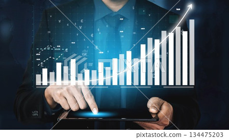 Businessman Using Tablet with Interface Displaying Financial Data Graphs and Charts for Stock Market Analysis and Business Growth Strategies Copula 134475203